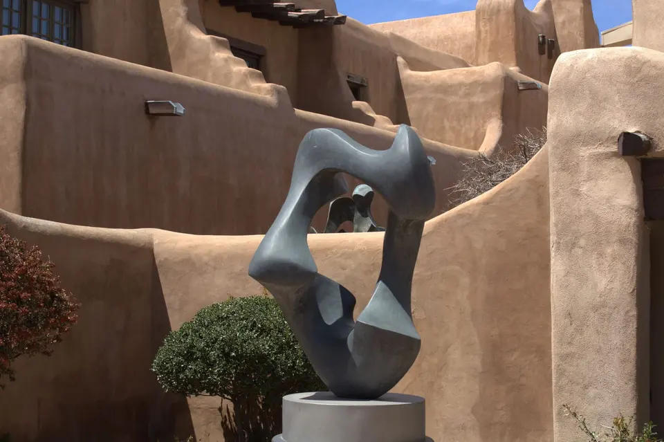 Earth-colored adobe walls along a narrow Santa Fe lane