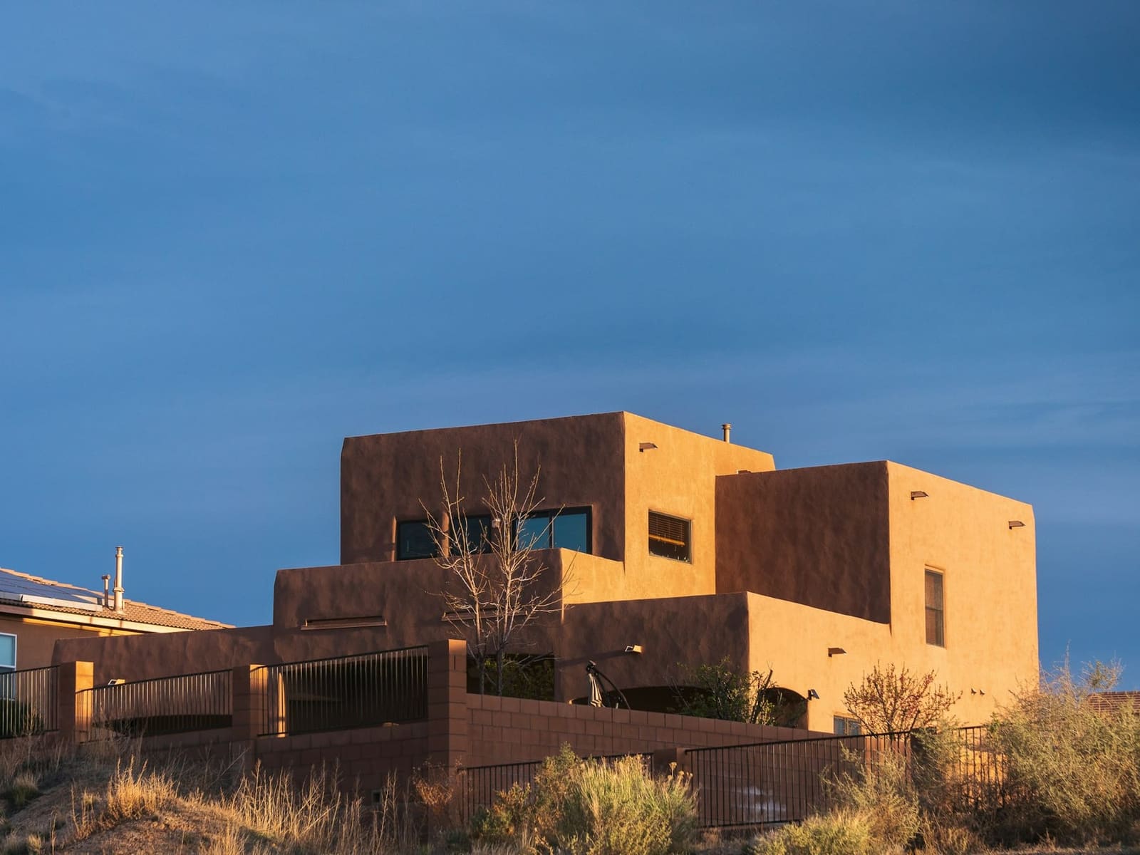 A contemporary adobe home in Santa Fe under a blue sky